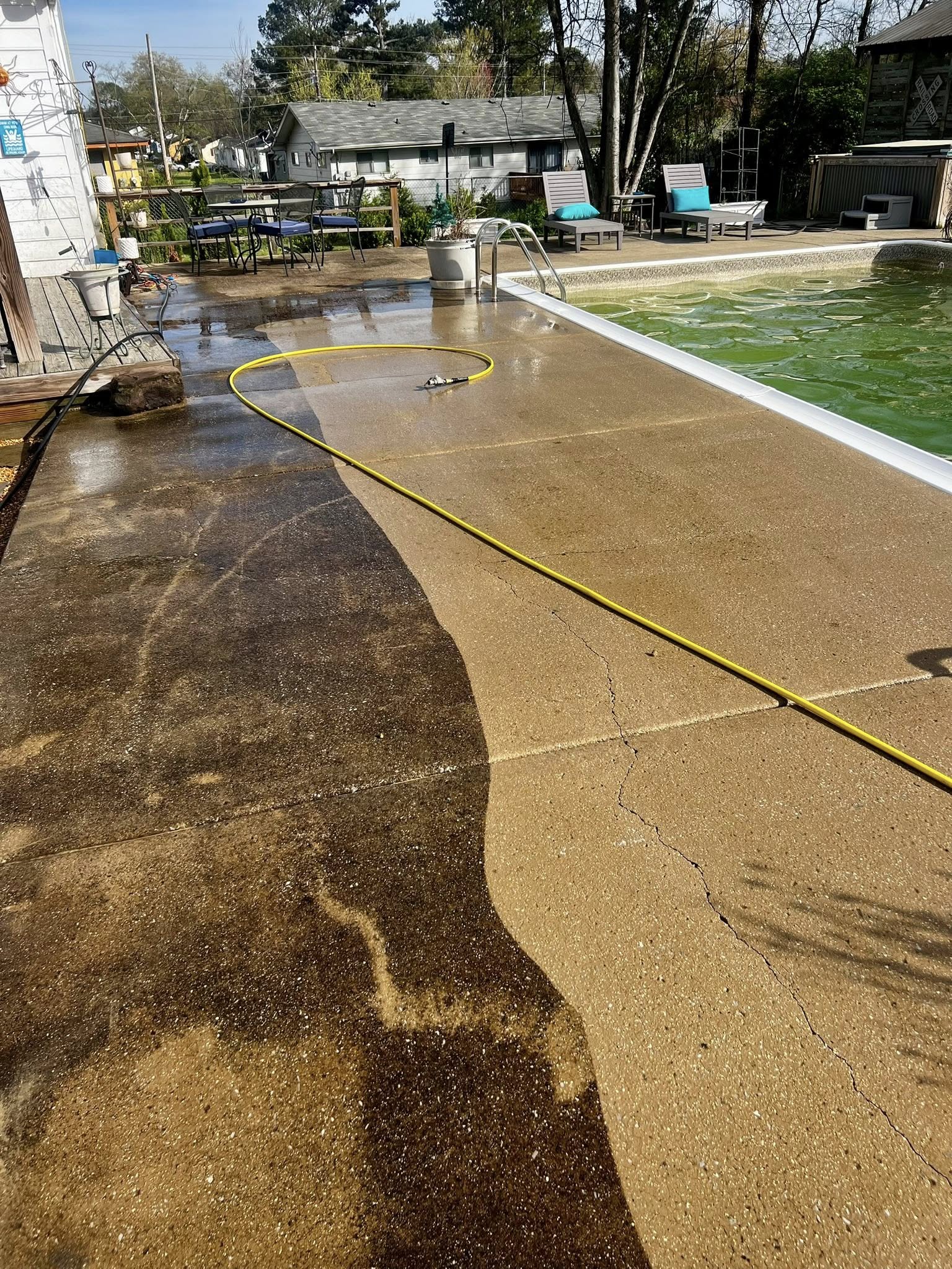 Pool deck during pressure washing — dramatic cleaning in progress